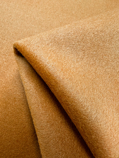 A photo of a wool that Super Cheap Fabrics stocks. Wool cashmere in a marmalade / apricot colour. Soft, heavy weight fabric suitable for winter clothing