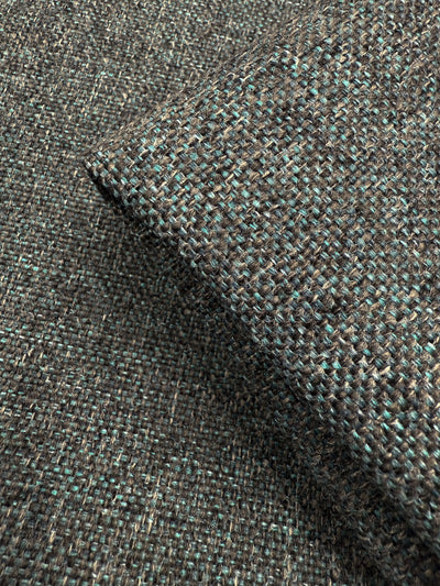 Close-up of Soho Topaz upholstery fabric by Super Cheap Fabrics, 150cm wide, with textured woven brown and teal threads—a medium weight ideal for upholstery. Folded corner highlights coarse, interlaced texture.