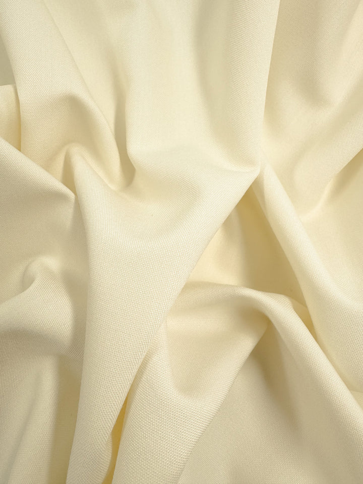 Super Cheap Fabrics’ Cotton Voile - Cream - 145cm is a lightweight, cream-colored cotton with soft folds and gentle shadows, giving a fluid, slightly crinkled look—ideal for elegant home decor projects.