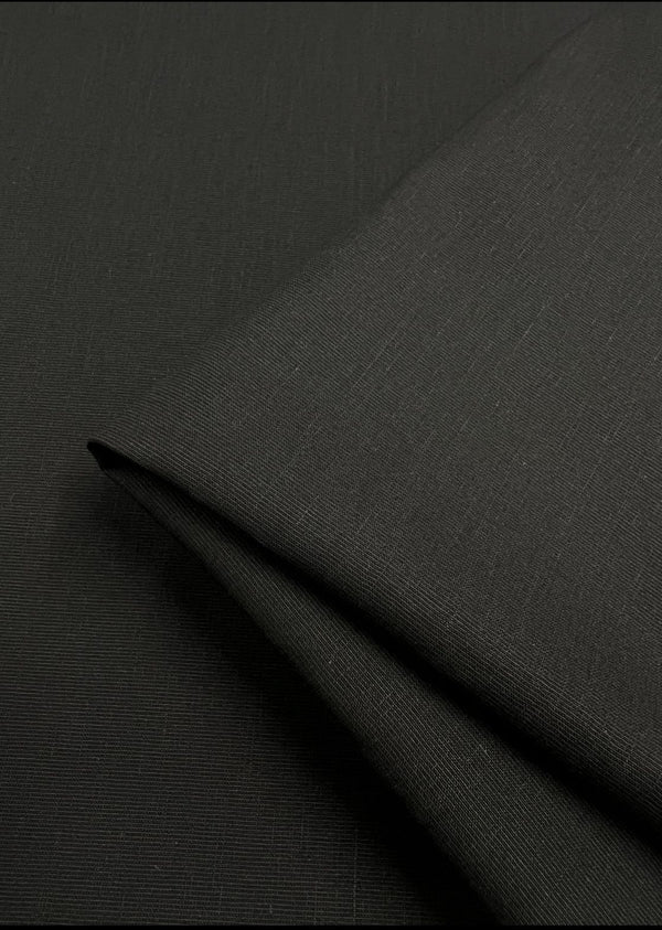 A close-up of Super Cheap Fabrics' Blended Viscose Suiting in black reveals a subtle textured weave, perfect for fancy dresses. The lighting highlights the smooth surface and soft texture of this 150cm drapey fabric.