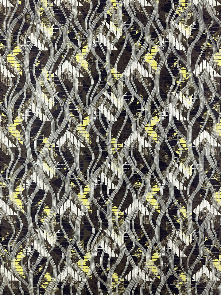 The Designer Mesh - Direction - 150cm from Super Cheap Fabrics showcases a striking, dynamic design with interwoven black, white, and yellow lines on a dark background. Its textured polyester finish is perfect for home décor.