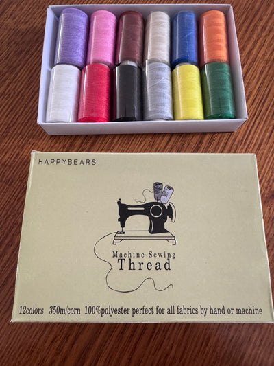 A Box of 12 Thread by Super Cheap Fabrics, each spool with 350m of vibrant 100% polyester, sits above its packaging featuring a sewing machine and the text "HAPPYBEARS Machine Sewing Thread, 12 colors.