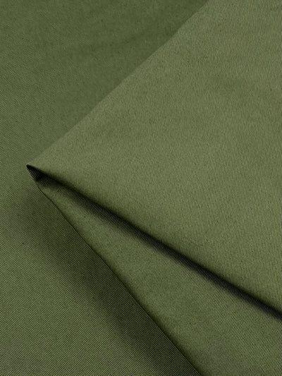 Close-up of green fabric with a fine, diagonal striped texture made from a cotton acrylic blend, neatly folded at the corners. The featured material is Canvas - Mayfly (150cm) by Super Cheap Fabrics.