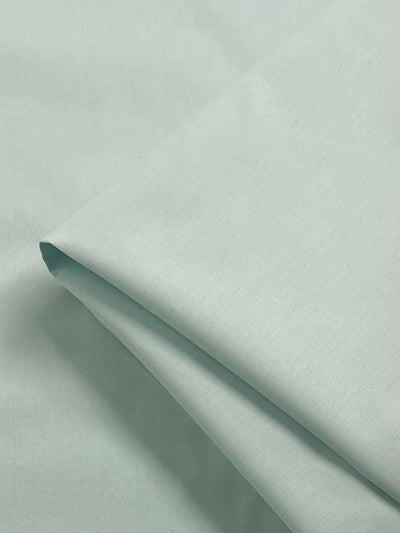 A close-up of Super Cheap Fabrics' Plain Cotton - Cooling Oasis - 156cm in light mint green shows its smooth, soft texture and lightweight feel—ideal for creating a cool, comfortable oasis.