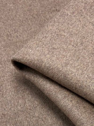 Close-up of a folded piece of extra heavyweight, textured greige wool cashmere from Super Cheap Fabrics. The fabric's soft surface looks warm and cozy, ideal for clothing or blankets.