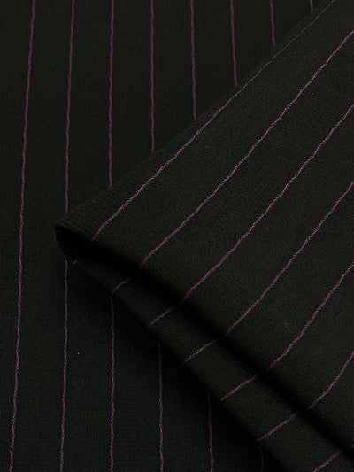 Close-up image of Microfibre Suiting - Black/Pink Stripe fabric, made from medium weight polyester by Super Cheap Fabrics. The fabric appears to be folded, clearly displaying its classic and elegant design with evenly spaced pink pinstripes against a black background. Fabric width is 150cm.