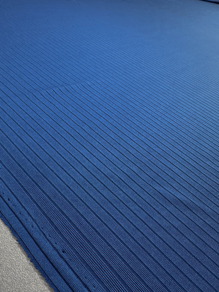 The surface of the Rib Knit - Classic Blue - 170cm by Super Cheap Fabrics features medium weight, vertical ridges for a textured look. Its generous stretch and lighting highlight its slightly glossy finish.