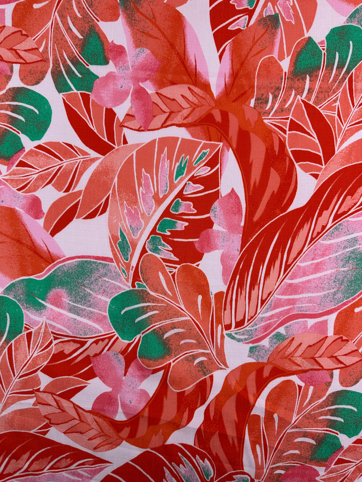 The Bamboo Rayon - Grapefruit Jungle - 145cm by Super Cheap Fabrics features a vibrant tropical pattern of overlapping red, pink, and green leaves and flowers on lightweight fabric. Its lush design on a white background is perfect for beginner-friendly sewing projects.