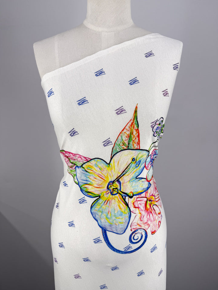 A mannequin displays the Super Cheap Fabrics Viscose Knit - Orchid (135cm), featuring a colorful, hand-drawn floral print with blue geometric patterns on breathable fabric.