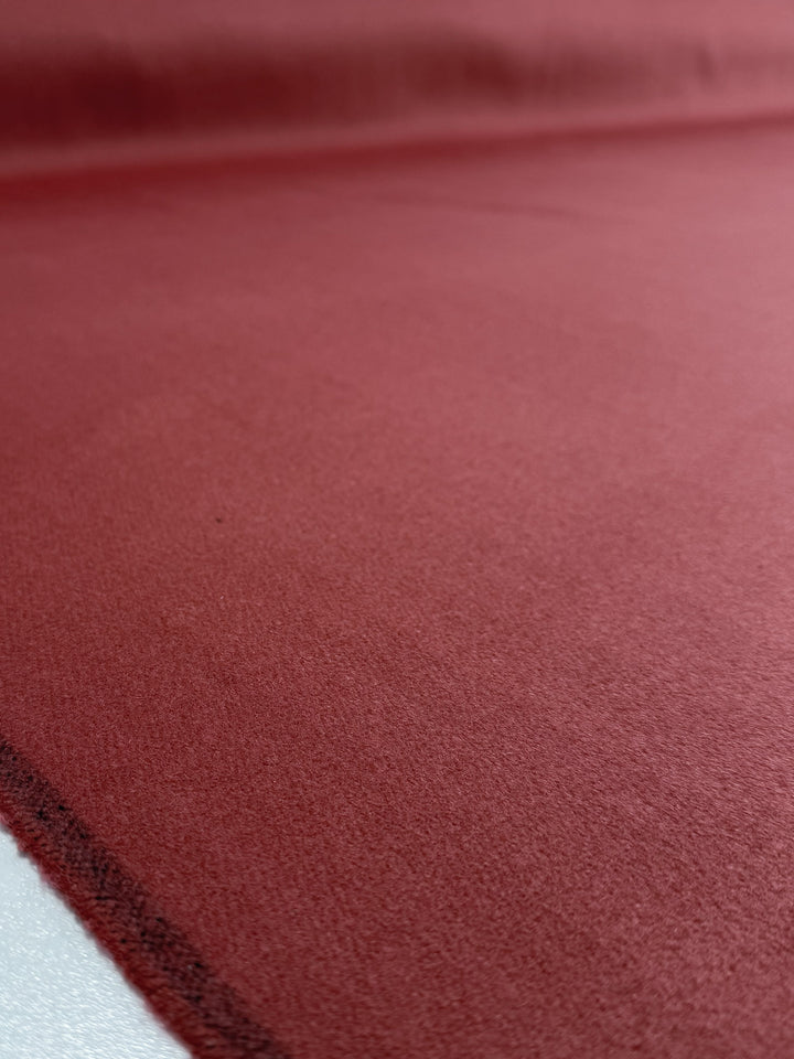 Close-up of Super Cheap Fabrics' Wool Cashmere in Red Ochre (150cm), showcasing its rich color, smooth soft texture, and subtle shadowing that highlights the premium quality of this luxurious material.