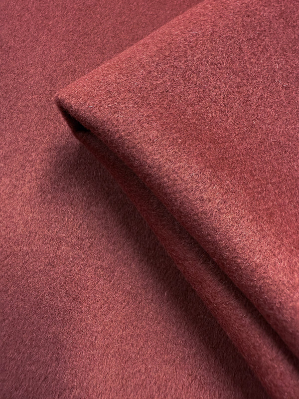 A close-up of Wool Cashmere - Red Ochre - 150cm by Super Cheap Fabrics reveals its soft, textured surface and fine fibers, crafted from premium wool cashmere in a muted red ochre hue.