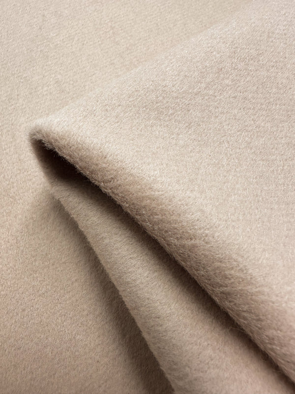 Close-up of light beige Wool Cashmere - Rose Dust (150cm) by Super Cheap Fabrics, featuring a soft texture and slight fold. Its fuzzy surface and gentle color exude luxurious softness, conveying warmth and comfort.