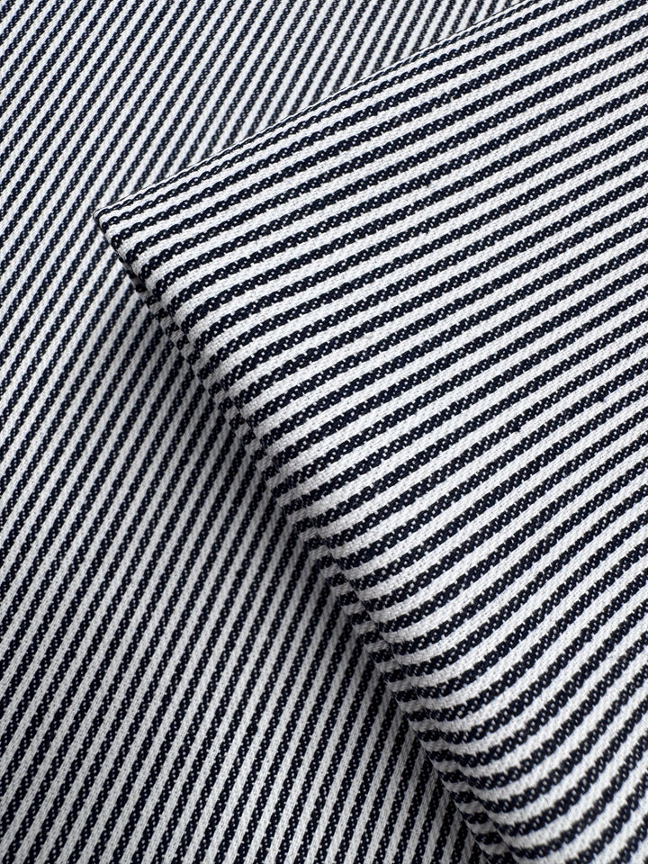 Close-up of two overlapping pieces of Super Cheap Fabrics’ Designer Cotton - Pintrack (150cm), showing black and white diagonal stripes at contrasting angles.