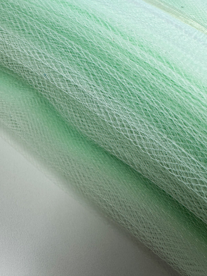 Close-up of Super Cheap Fabrics' Soft Tulle - Patina Green (150cm), featuring fine net texture and visible layered detail on a light background—ideal for costumes or bridal veils.