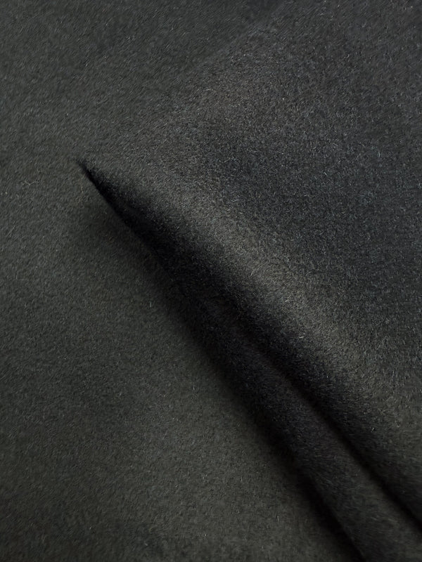 A close-up of Wool Cashmere - Darkest Teal - 150cm by Super Cheap Fabrics highlights its soft, heavy weight, smooth and velvety texture with a slight fold.