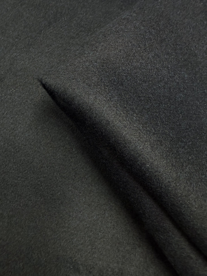A close-up of Wool Cashmere - Darkest Teal - 150cm by Super Cheap Fabrics highlights its soft, heavy weight, smooth and velvety texture with a slight fold.
