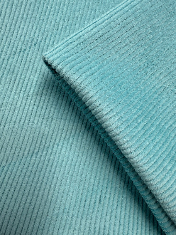 Close-up of Super Cheap Fabrics' Mid Wale Corduroy in Pastel Turquoise (145cm), showing its soft texture and visible vertical ridges with two overlapping pieces.