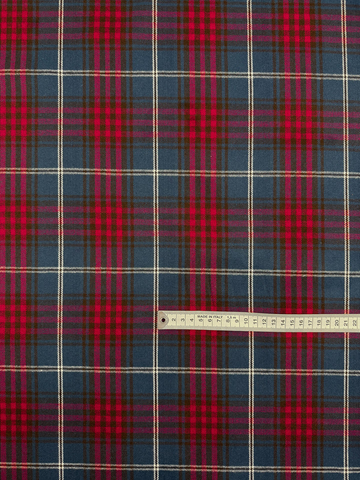 A close-up of Flannel Tartan - Stirling Rose by Super Cheap Fabrics, a medium weight 100% cotton flannel (145cm) in red, blue, and green plaid with white stripes. A ruler at the bottom right shows scale.