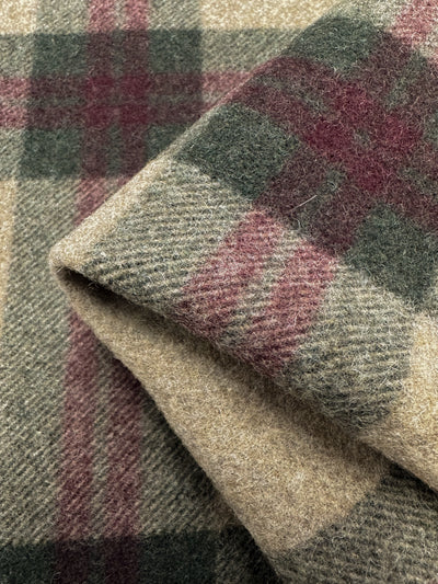 Close-up of a folded Wool Flannel - Farmhouse - 150cm from Super Cheap Fabrics displaying a plaid pattern in beige, green, and maroon colors. The medium to heavy weight wool fabric is visibly soft and warm, highlighting the weave and material quality.