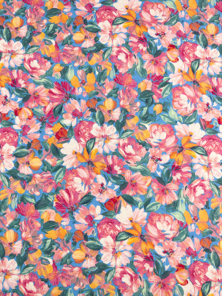 Introducing the "Soft Cotton - Acrylic - 140cm" fabric from Super Cheap Fabrics, featuring a vibrant floral motif with an array of pink, yellow, orange, and white flowers complemented by lush green leaves. The densely packed flowers create a colorful and eye-catching design that brings a lively, summery feel to any project. Made from soft cotton with an acrylic blend, the background is entirely adorned with this beautiful floral pattern.