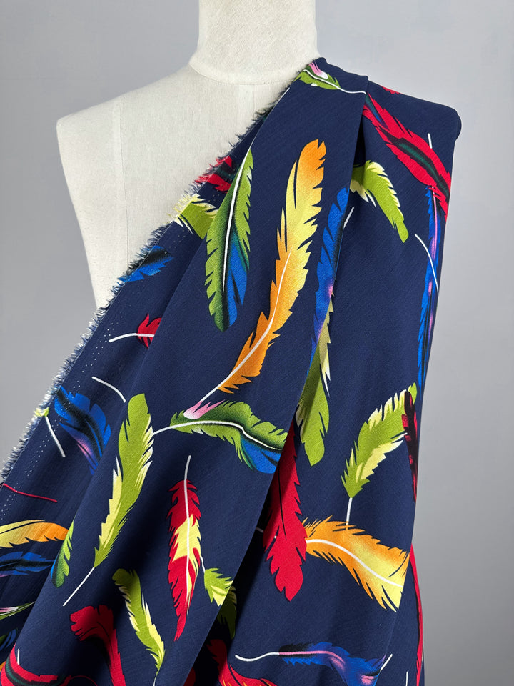 A headless mannequin displays Bamboo Rayon - Feather Blue - 150cm by Super Cheap Fabrics, a soft, lightweight fabric with colorful feathers and unfinished edges—ideal for beginner sewing projects.