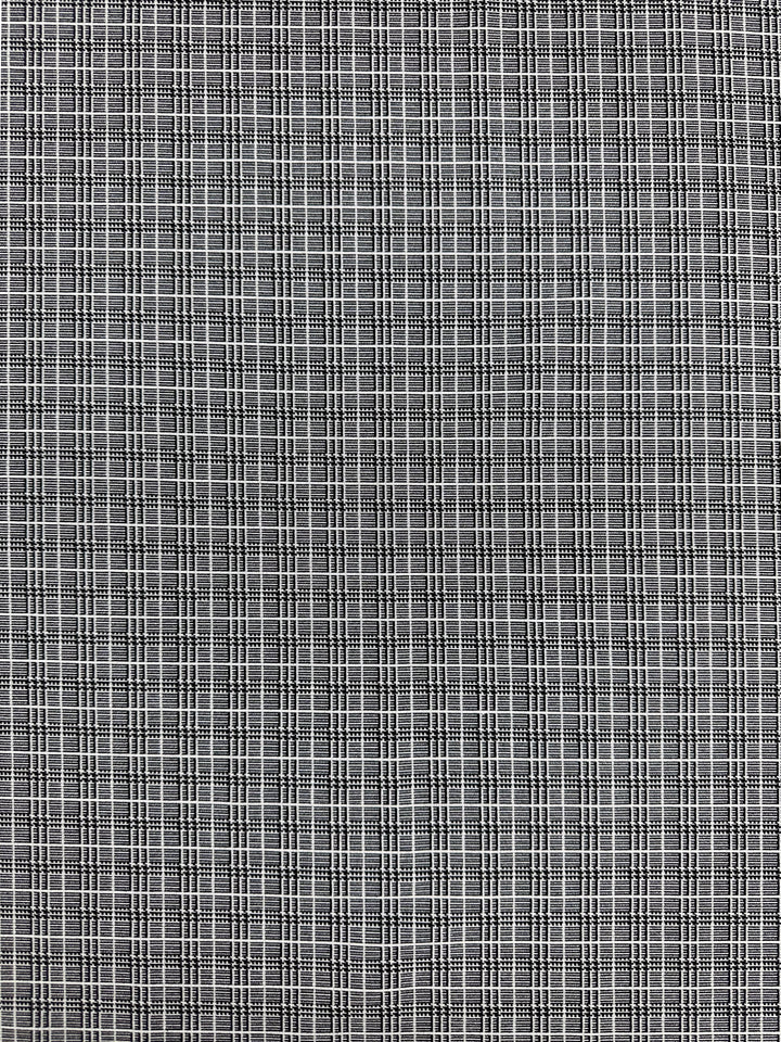 A close-up view of Super Cheap Fabrics' Textured Bengaline - Plaidly - 150cm reveals a medium-weight fabric with a small checkered pattern. The design features tiny black and white squares meticulously arranged in a grid, creating a uniform and repeating pattern across the surface. This versatile and durable fabric is suitable for multiple uses.