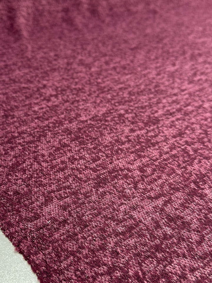 A close-up of Super Cheap Fabrics' Textured Knit - Tulipwood (150cm) shows its maroon, medium-weight fabric with a subtle mottled pattern displayed flat.