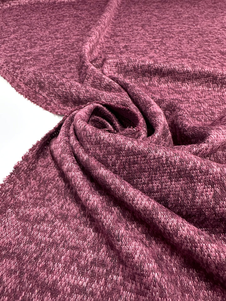 A close-up of Super Cheap Fabrics’ Textured Knit - Tulipwood - 150cm shows its heathered pinkish-purple tone and swirled folds, highlighting the unique texture and medium weight of this quality knit fabric.