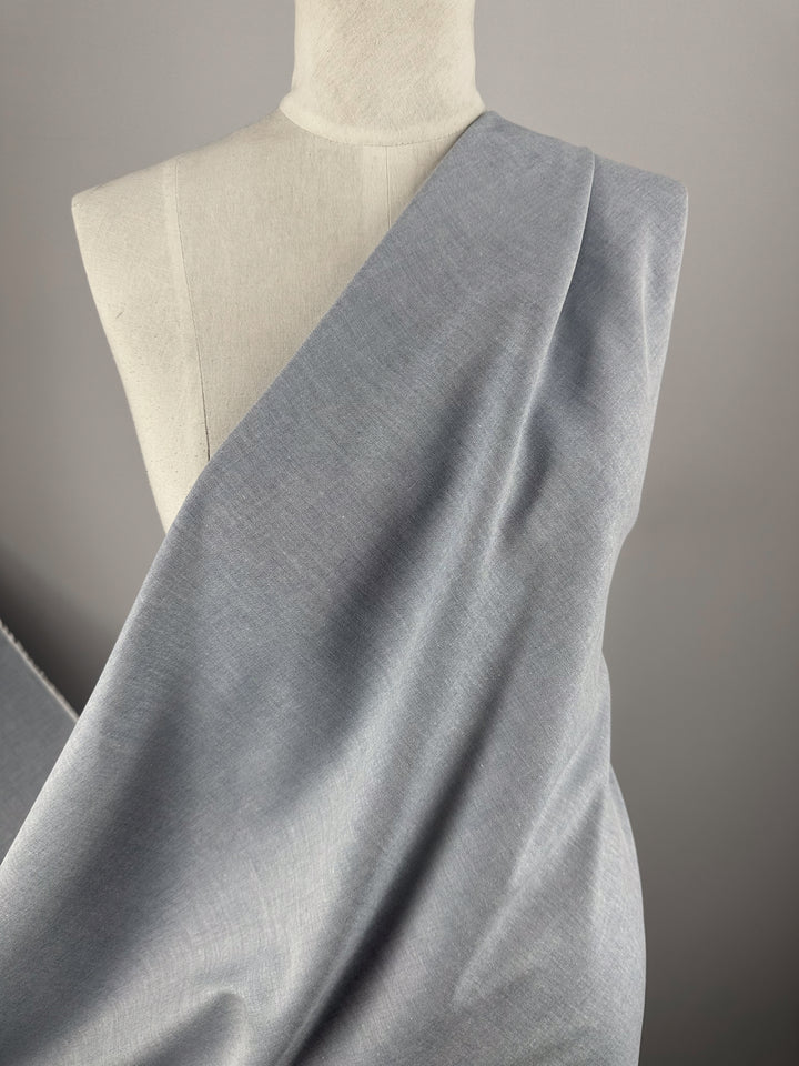 A dressmaker’s mannequin draped with Super Cheap Fabrics’ Oxford Cotton - Denim - 146cm, the fabric wrapped diagonally across the torso against a plain, neutral background.