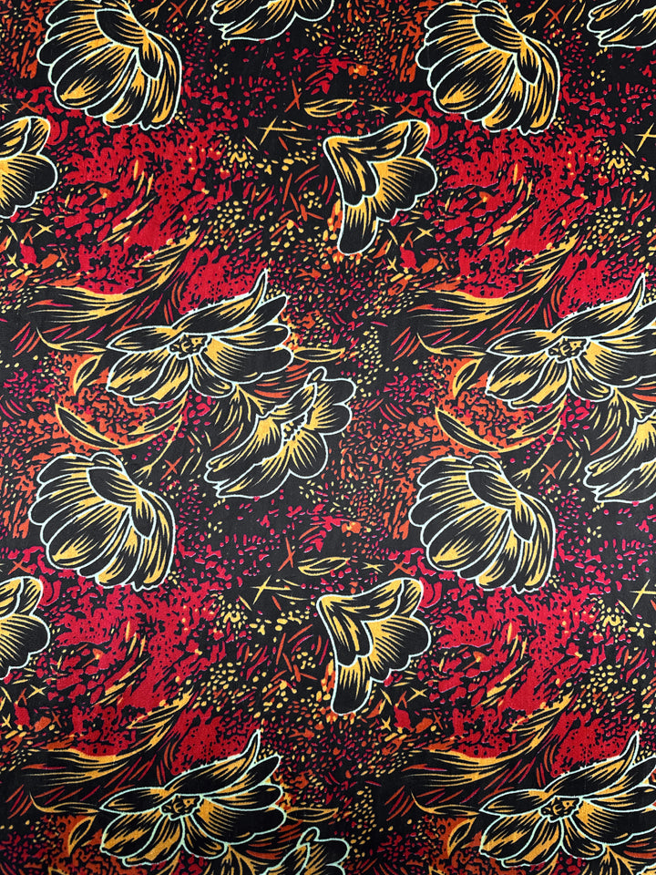 DD Velvet - Ember Bloom - 150cm by Super Cheap Fabrics features a colorful abstract floral pattern with large yellow and beige flowers outlined in black on a red, orange, and black speckled medium weight velvet.