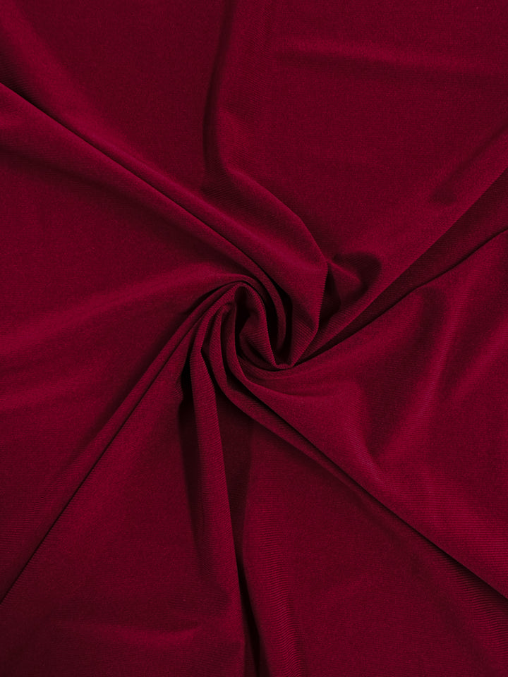 The Super Cheap Fabrics ITY Knit - Red Bud (150cm) features a deep red, medium-weight, soft-textured fabric with gentle swirling folds—perfect for loose pants or projects needing interlock twist yarn fabric.