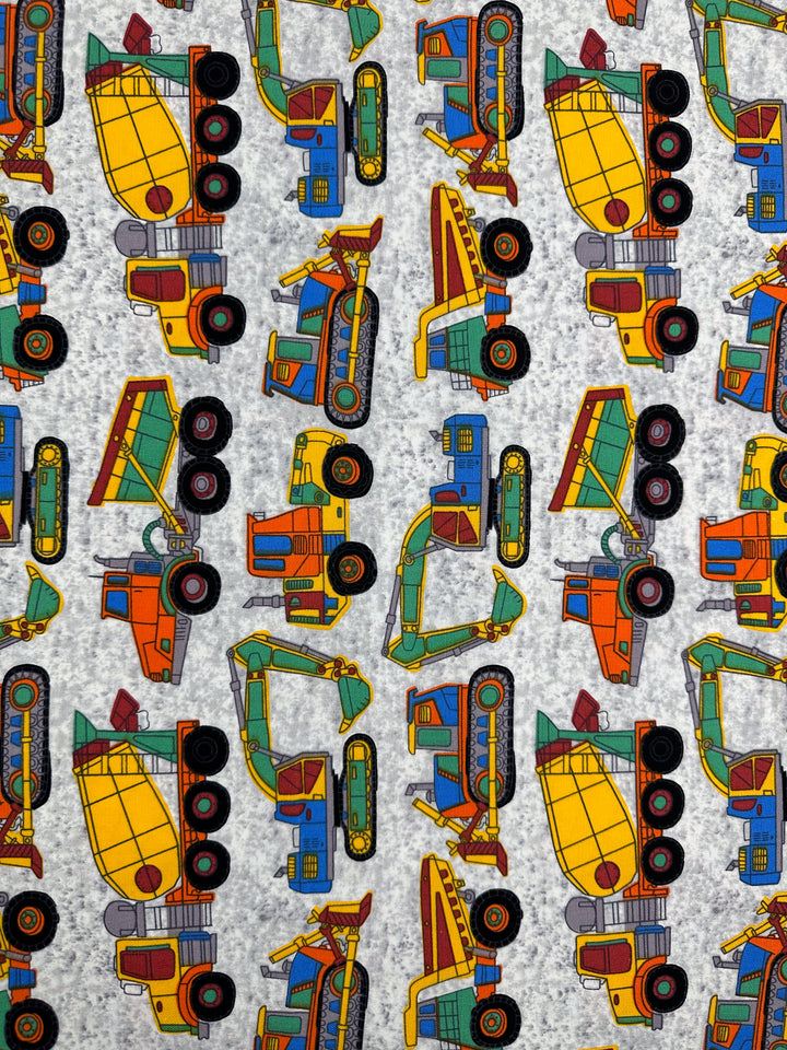 The Cotton Duck - Construction - 112cm fabric from Super Cheap Fabrics features a lively, illustrated pattern of colorful construction vehicles, including cement mixers, dump trucks, and excavators. The design comes to life on a textured gray cotton fabric and is perfectly suited for medium-weight home décor projects. Its vibrant orientations add a playful touch to any space.