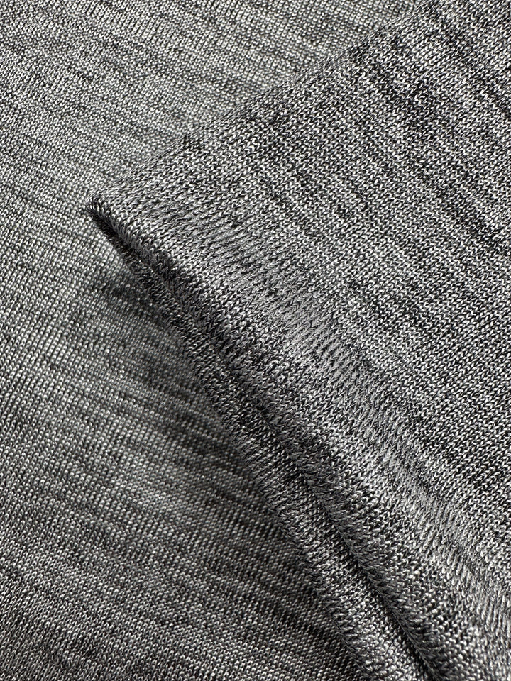 Close-up of Super Cheap Fabrics' Textured Knit - Greyline Lamé (145cm): two gray knit pieces, one partially folded over the other, showcasing the weave pattern and subtle metallic sheen.