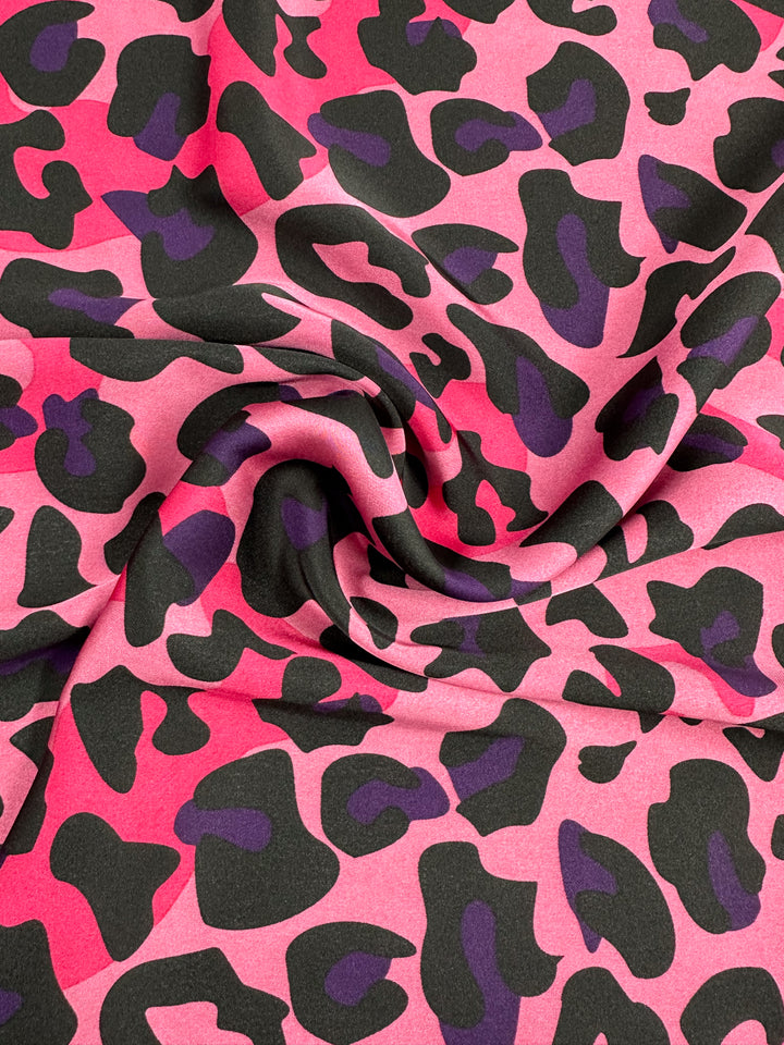 A lightweight satin fabric from Super Cheap Fabrics, featuring the "Silky Satin - Pinky - 150cm" with a pink and black leopard print.