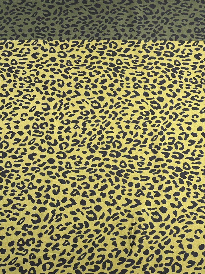 A sophisticated fabric from Super Cheap Fabrics, the "Silky Satin - Leon - 150cm," showcases a striking yellow and black leopard print.