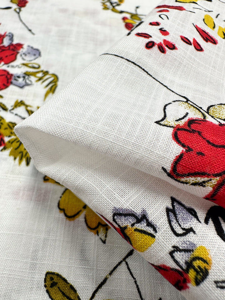 Close-up of Super Cheap Fabrics' Linen Blend - Scarlet Vine, 145cm wide, showcasing breathable linen with red, yellow, and purple floral patterns on a white backdrop—ideal for summer outfits.