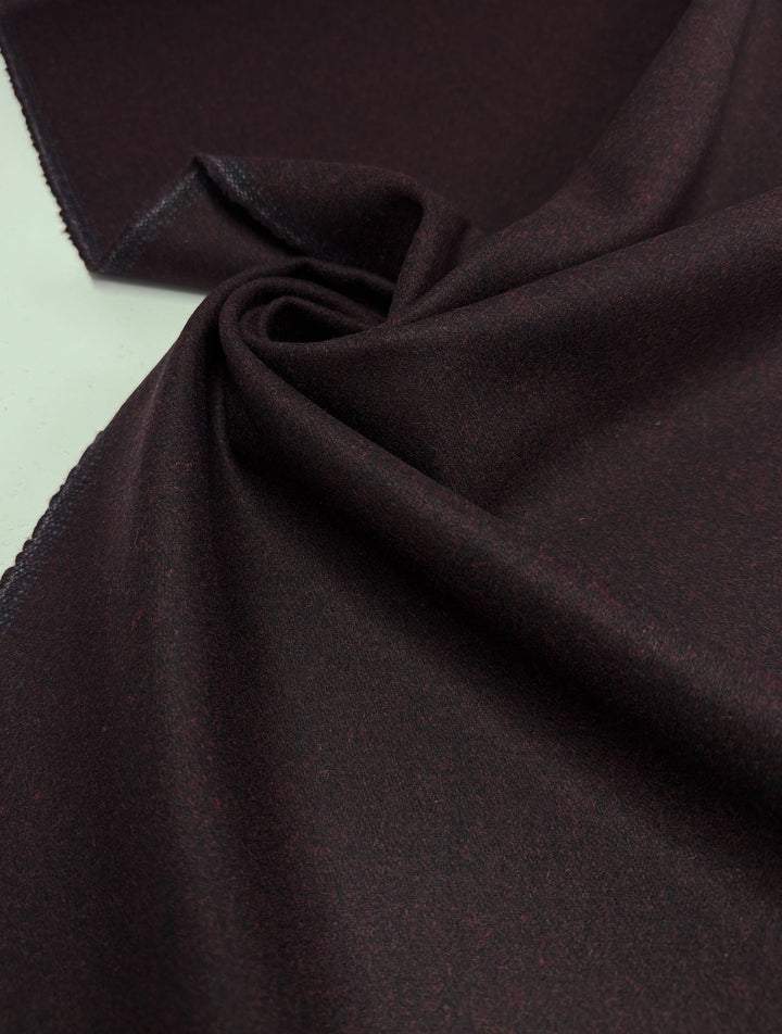 A close-up of Super Cheap Fabrics' Melton Wool - Valentine Marle (152cm), showing its rich burgundy tone and subtle texture, draped in soft folds—ideal for creating stylish outerwear.
