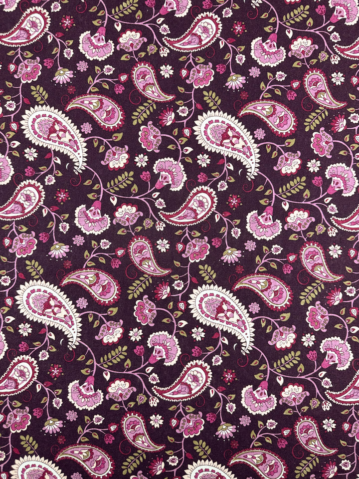 The Linen Blend - Paisley - 140cm by Super Cheap Fabrics features pink and white paisley with floral elements on a dark purple background. The intricate motifs create an elegant texture, ideal for elevating home decor with its medium weight allure.