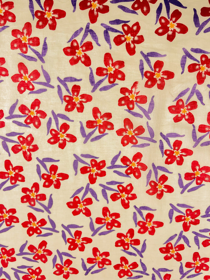 The Linen Voile - Bloom by Super Cheap Fabrics features a lightweight voile adorned with a design of red flowers with yellow centers and purple leaves against a light beige background, spanning 150cm.