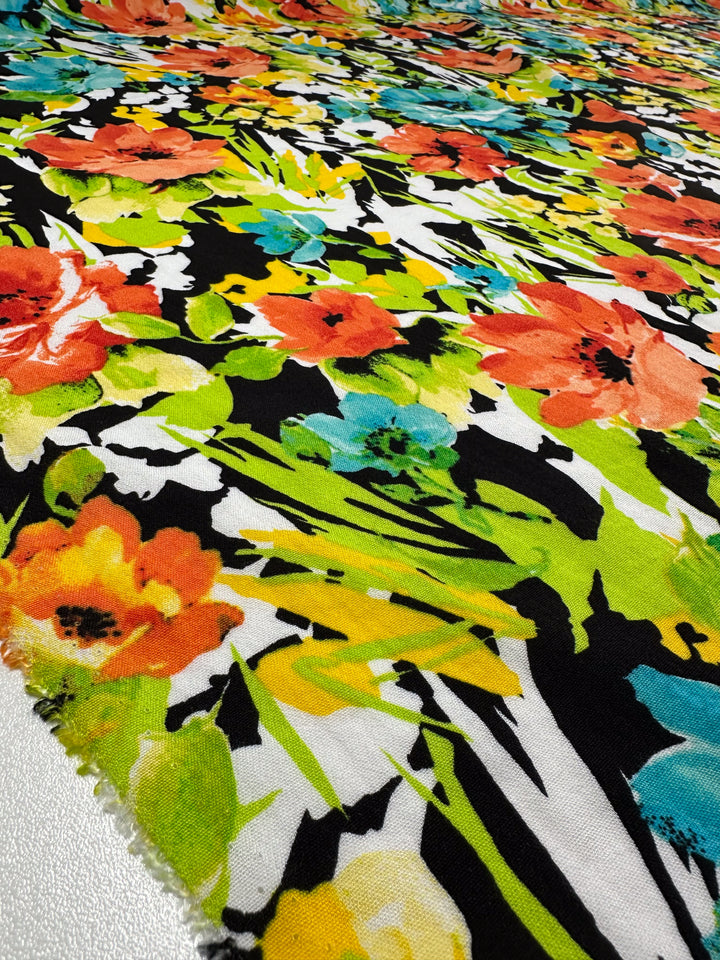 The vibrant Linen Blend - Black Forest by Super Cheap Fabrics features red, orange, yellow, and teal flowers with green leaves on a black backdrop. This dynamic 145cm fabric is perfect for various home decor uses.