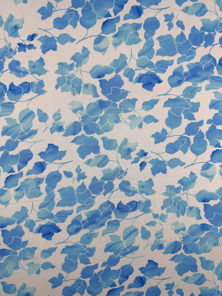 Mercerised Rayon - Blue Ginkgo by Super Cheap Fabrics features blue watercolor ginkgo leaves on a light beige background, creating an artistic botanical design ideal for breathable fabric. Width: 150cm.