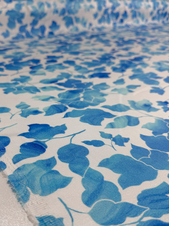 Close-up of Super Cheap Fabrics’ Mercerised Rayon - Blue Ginkgo (150cm): lightweight, breathable fabric with a soft texture, slight sheen, and blue watercolor ginkgo leaf pattern on a white background.