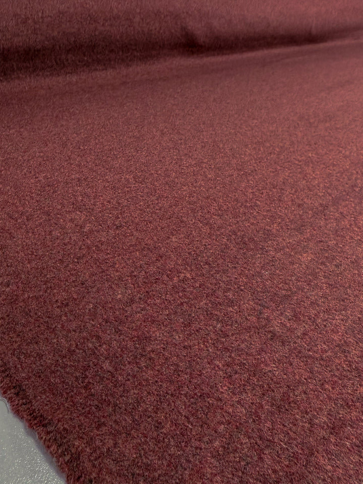 A close-up of Super Cheap Fabrics’ Wool Cashmere - Mahogany Marle (154cm) showcases its soft, textured maroon surface, spread smoothly to highlight the fabric’s luxurious feel.