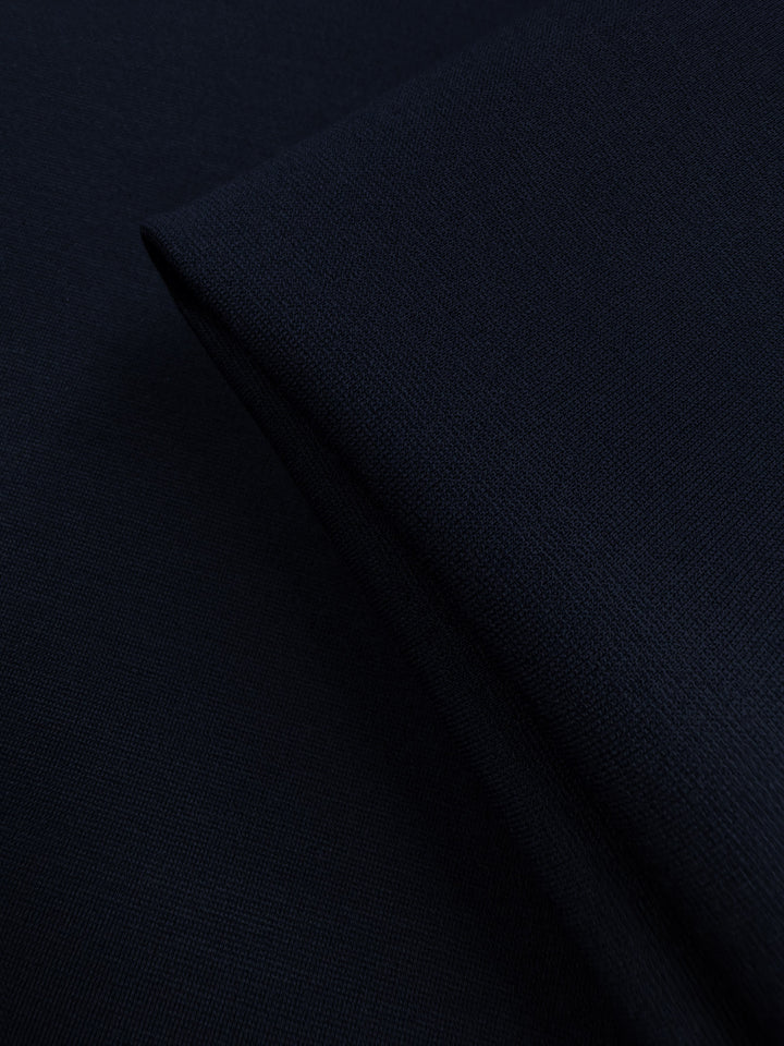 A close-up of Super Cheap Fabrics' Milano Ponte in Mood Indigo (160cm), showcasing its dark navy hue, smooth yet textured surface, and subtle weave for a soft, structured look.