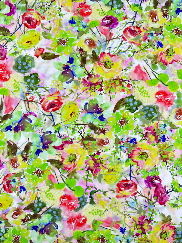 The Designer Rayon Sierra from Super Cheap Fabrics, with a vibrant floral pattern of pink, yellow, red, and blue flowers on soft rayon fabric. Scattered green leaves enhance its cheerful and dynamic design, making it versatile for any setting. Width: 145cm.