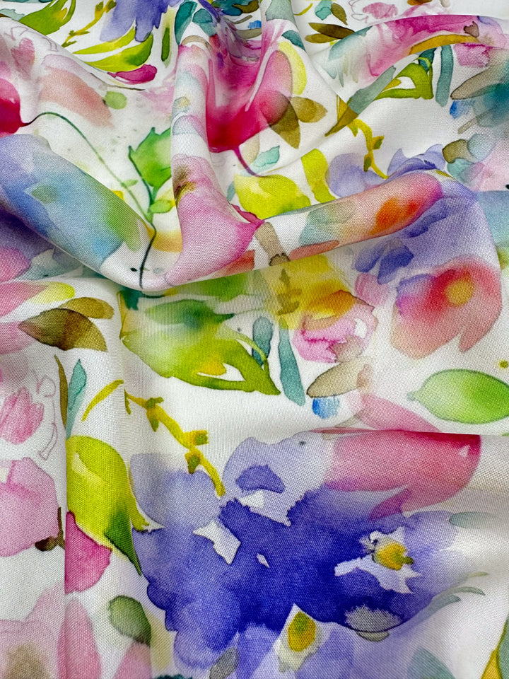 The Designer Rayon - Milana from Super Cheap Fabrics is a versatile, textured fabric with a colorful abstract floral print in shades of pink, purple, yellow, and green.