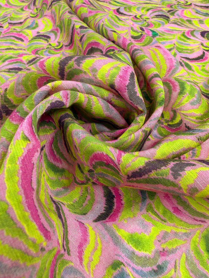 A close-up of Super Cheap Fabrics’ Textured Designer Cotton - Neon Vortex (145cm), showcasing its swirling neon pattern in pink, green, yellow, and black—perfect for quilting or designer projects.
