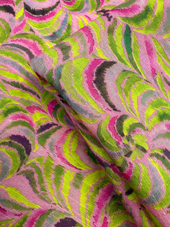 Close-up of Super Cheap Fabrics' Textured Designer Cotton - Neon Vortex (145cm), featuring a swirling pink, green, yellow, and black abstract pattern. This lightweight cotton is ideal for designer projects or quilting.