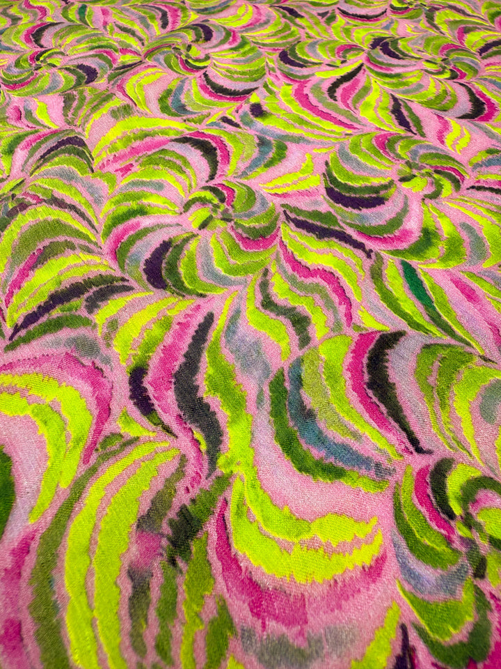 Close-up of Super Cheap Fabrics’ Textured Designer Cotton - Neon Vortex (145cm), featuring a vibrant, wavy abstract pattern in neon pink, yellow, green, and dark purple for a bold textured look.