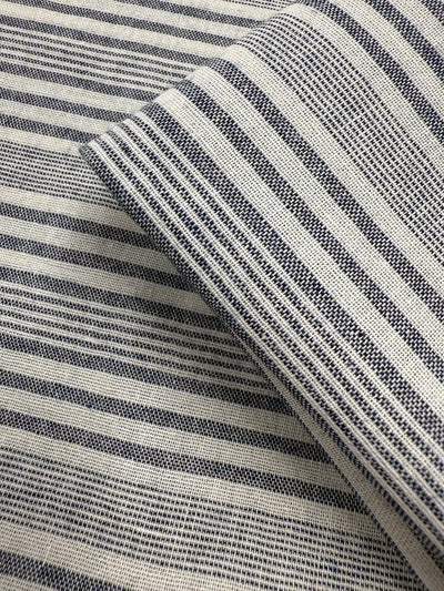 Close-up of two layered pieces of Super Cheap Fabrics' Linen Blend - Coastal Navy Stripe (140cm), showcasing a woven texture with horizontal navy and white stripes in varying thicknesses.